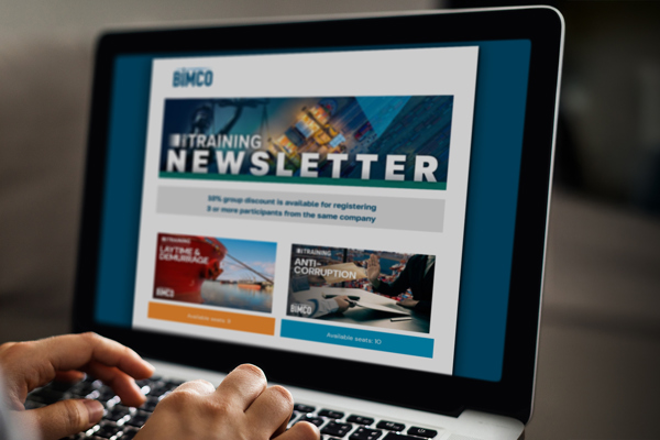 Laptop screen with hands typing on keyboard. Screen shows BIMCO Training newsletter
