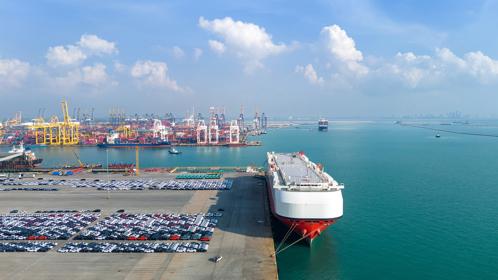 Cars lined up on quayside next to VLCC