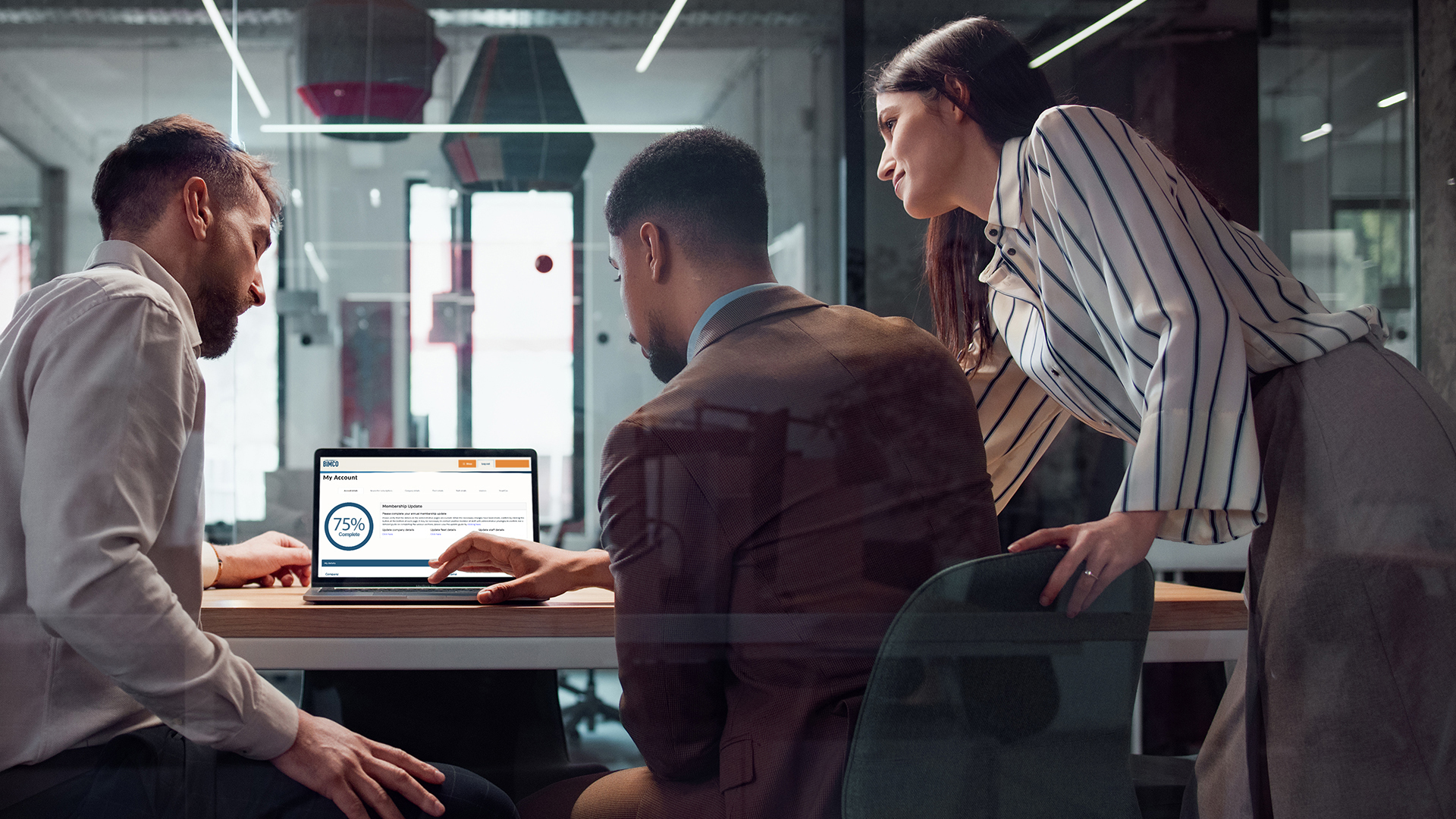 Three business people looking at a computer