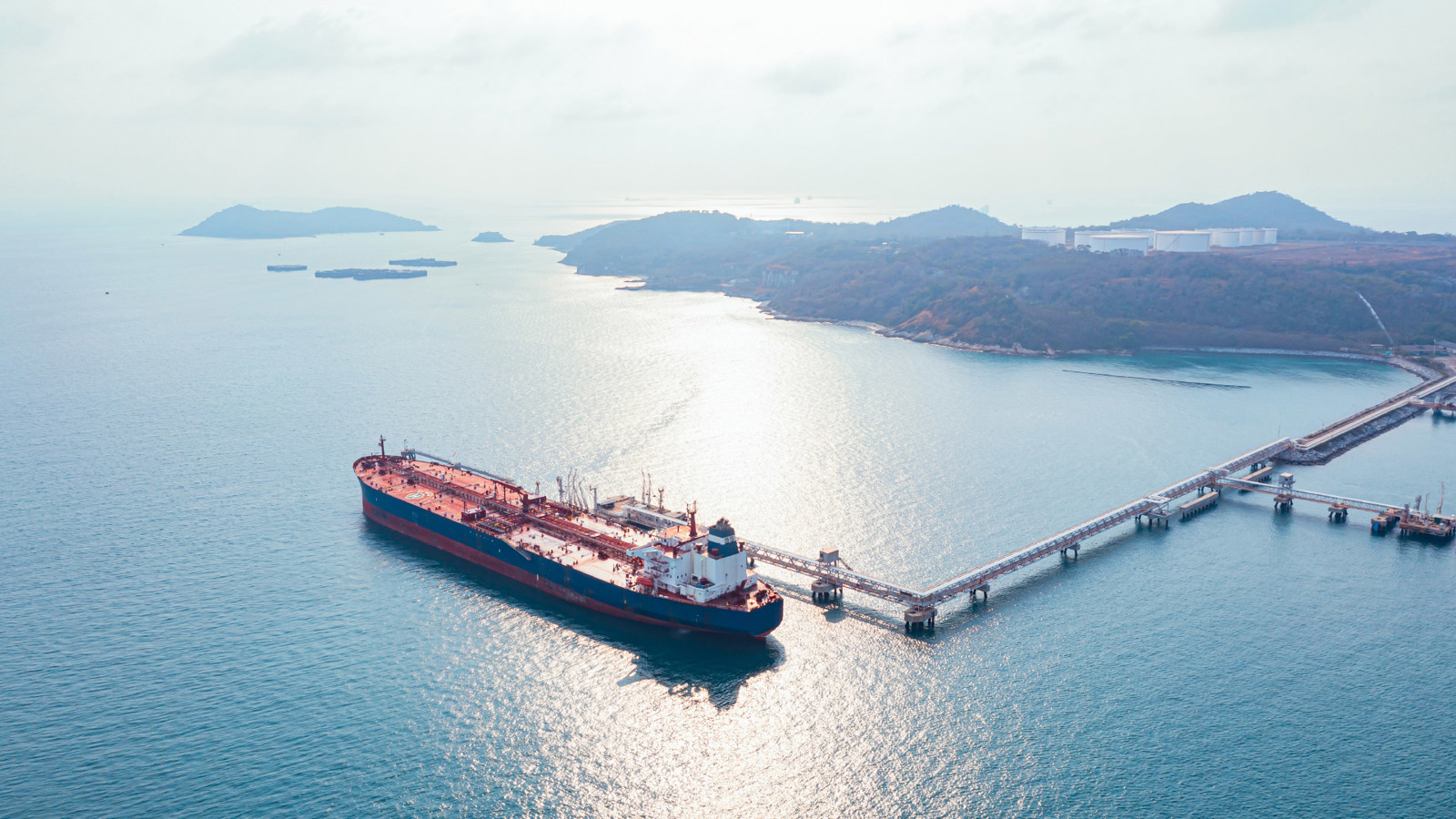 Tank ship being unloaded at terminal at sunset