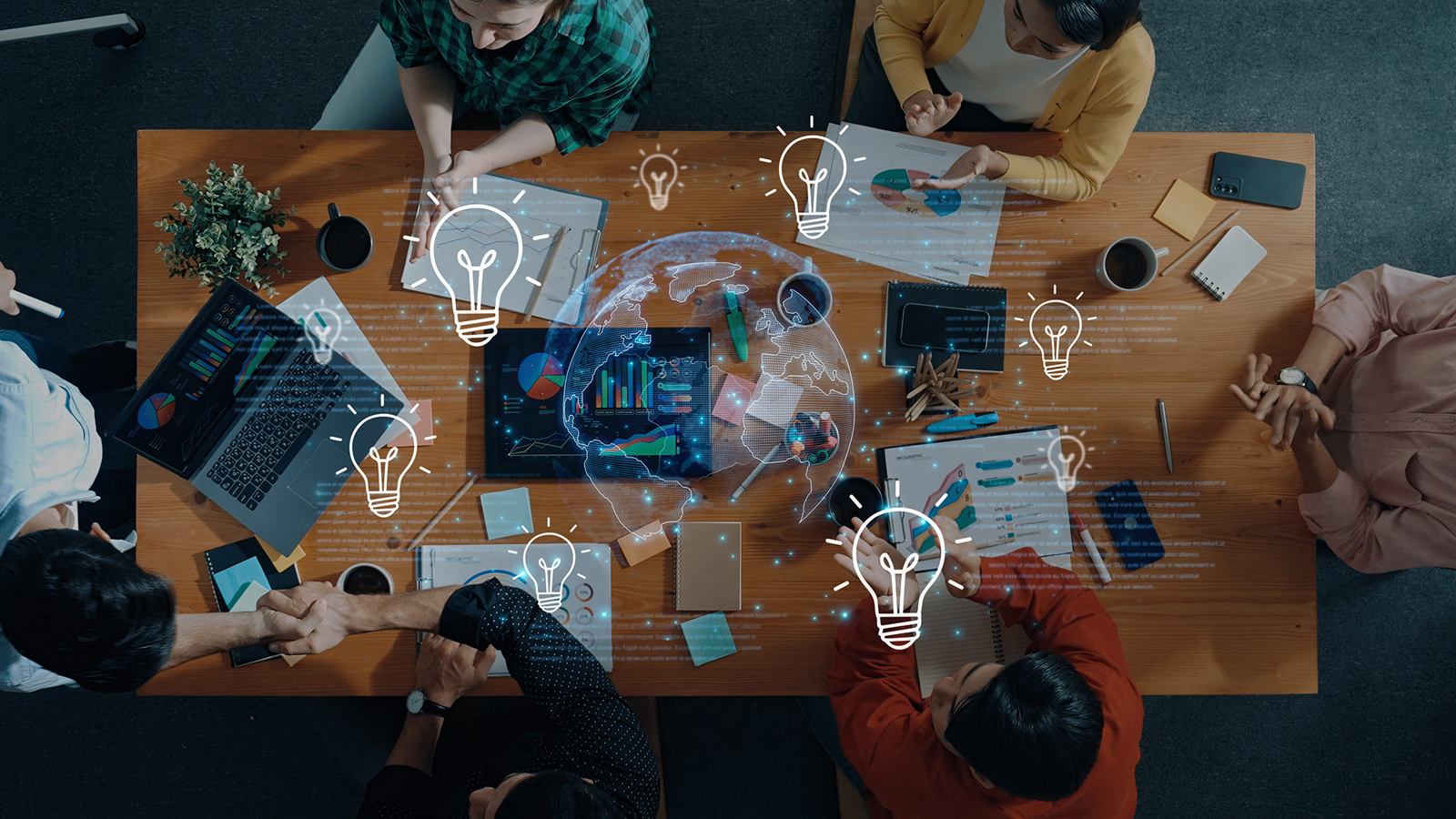 View from above of a conference table with people working on laptops
